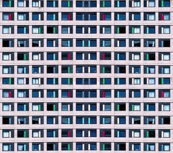 Residential cells of the hostel building. Modern minimalistic architecture with a lot of square glass windows and colors on the building. The rhythm of the windows. Geometric pattern.