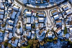 Aerial drone view of small residential streets covered in snow during winter