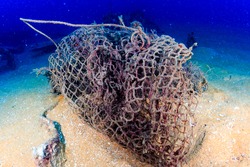 An abandoned fishing net (ghost net) on the sea floor