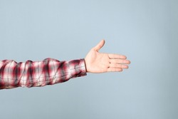 The Asian man hand with plaid shirt showing on the blue background.