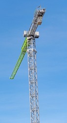 Top of a tower crane with a boom and a crane operator's cab