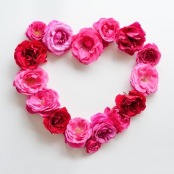 Heart symbol made of pink roses on white background. Flat lay beautiful flowers. Roses for love concept.