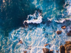 Aerial view of waves and some of rocks.
