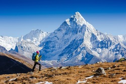 Woman Traveler hiking in Himalaya mountains with mount Everest, Earth's highest mountain. Travel sport lifestyle concept. Ama Dablam mountain view