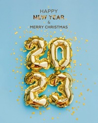 Happy New Year 2023 greeting card. 2023 golden foil balloons numbers and confetti. Top horizontal view copy space new year and christmas holiday concept.