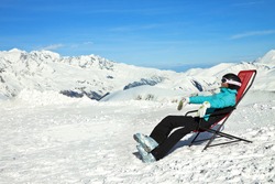 Girl relax in snowy mountains. Ski vacation