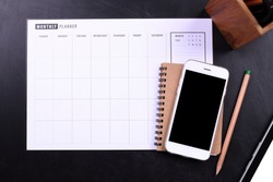 blank screen smartphone with notebook and planner schedule