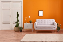 Orange living room and orange wall background light grey sofa and avangard white door. Modern home decoration brown parquet and carpet design.