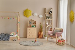 Wooden house bed detail cabinet and stair decor. Yellow sun and cloud decor. Pink chair in the room.