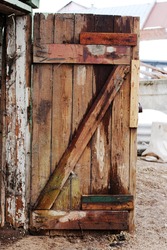Old decayed wooden door. Door made of discoloured pine timber