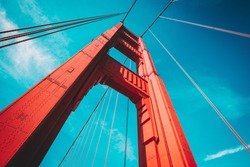 Beautiful low angle view of famous Golden Gate Bridge with blue sky and clouds on a sunny day in summer with retro vintage post crocessing filter effect, San Francisco Bay Area, California, USA