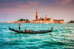 Panoramic view of traditional Gondola on Canal Grande with San Giorgio Maggiore church in the background in beautiful evening light at sunset, San Marco, Venice, Italy