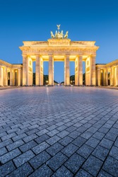 Classic vertical view of historic Brandenburg Gate, Germany's most famous landmark and a national symbol, in post sunset twilight during blue hour at dusk in summer, central Berlin, Germany