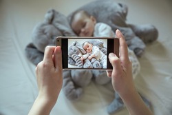 Mother shootin her sleeping newborn baby by smartphone