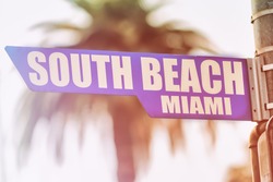 South Beach Miami Street Sign. A street sign marking South Beach, Miami. Backed by a palm tree with a sunset flare.