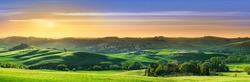 Panorama, Italian beautiful landscape, green rolling Tuscan fields in warm light of the setting sun