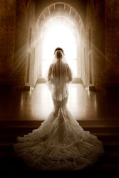 Bride Back Side View walking down Aisle Church. Woman In Window Door Light. Wedding Ceremony Day. Bridal Dress long Train and Lace Veil. Indoor Art Portrait