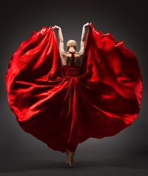Ballerina Dancing in Red Flying Dress Rear Back Side View. Graceful Woman Ballet Performer in Flamenco Skirt. Expressive Passion Dance in Motion over Dark Background