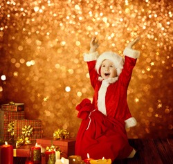 Christmas Kid, Happy Child Presents Gifts and Red Santa Bag, Boy Arms up, Golden Xmas Lights