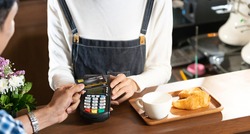 Asian customer using contactless credit card nfs technology pay to barista at cafe bar. Contactless payment preventing from coronavirus covid-19 Spreading and infection, Panoramic web banner crop.