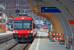 Red Train locomotive coming to Interlaken platform Station Switzerland