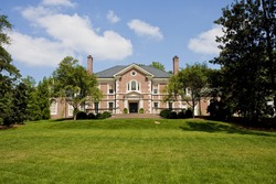 A large estate on top of a green grassy hill