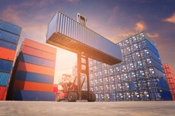 Forklift truck handling cargo shipping container box in logistic shipping yard with cargo container stack in background