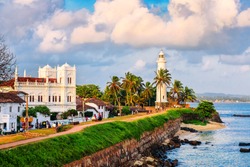 White lighthouse on tropical island on sunset. Fort Galle. Sri Lanka