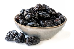 Bowl of fresh juicy pitted prunes over white background.