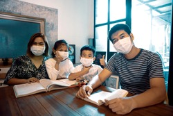 asian family quarantine at home reading book in home living room