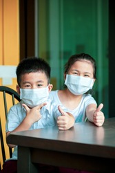 asian children wearing protection mask happiness at home while covid-19 virus infected in bangkok thailand