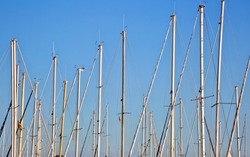 White boat and yacht masts with rigging on a blue sky background of Mallorca island. Spain