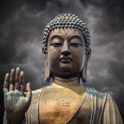 The statue of Big Buddha face with hand in Hongkong on  storm clouds background 