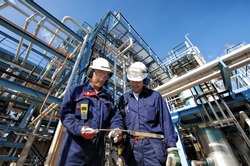 two oil and gas workers with main station at refinery industry