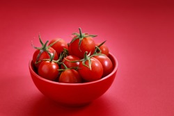 red cherry tomato on colorful red background