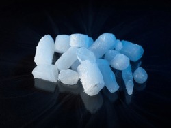 Dry Ice nuggets sublimating in room temperature. Isolated on black background.