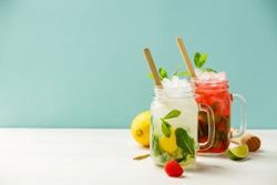 Fresh cocktail drinks with ice fruit and herb decoration. Alcoholic non-alcoholic drink-beverage. Mojito on blue background