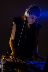 Female DJ playing music on a mixer. Blue light flare visible