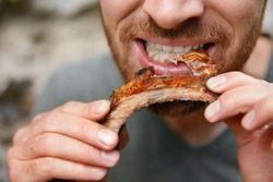People Eat Food. Man Eating Barbecue Ribs In Grill Bar Closeup. Male Eating Spareribs In Steak House. High Resolution 