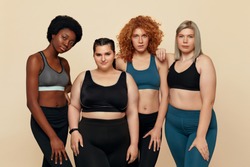 Diversity. Group Of Models With Different Figure Size And Body Types Portrait. International Friends In Sportswear Posing On Beige Background. Body Positive As Lifestyle.