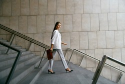 Business Women Style. Woman Going To Work Walking Downstairs. Portrait Of Beautiful Smiling Female In Stylish Office Clothes Going Down Stairs. High Resolution.