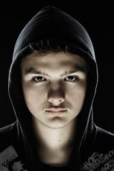 Closeup of a teenager wearing a hoodie, underlit
