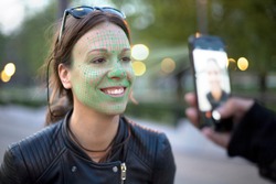 face recognition technology activated while taking a photo of a young woman with mobile phone