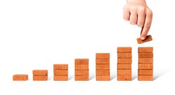 Business concept growth success process - Hand adding brick stacking as step stair on white background, including clipping path 