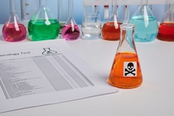 Toxic report for orange juice and colored chemical flasks. Toxicology analysis for food safety of orange drink. Food control of colored fluids. Paper report page of poison component analysis.