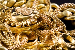 Closeup of yellow gold jewelery on a black background 
