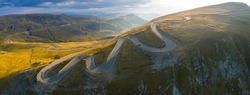 Aerial panoramic view of amazing curved road through the mountains - Transalpina in Romania during an autumn sunrise
