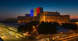 Palace of the Parliament building in Bucharest with the national flag of Romania projected on it