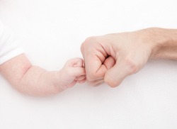 Fist of Dad and Newborn Baby. Fist to fist