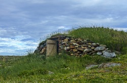 Door is open on rustic, underground root cellar in Elliston on Bonavista Peninsula in Newfoundland, Canada.